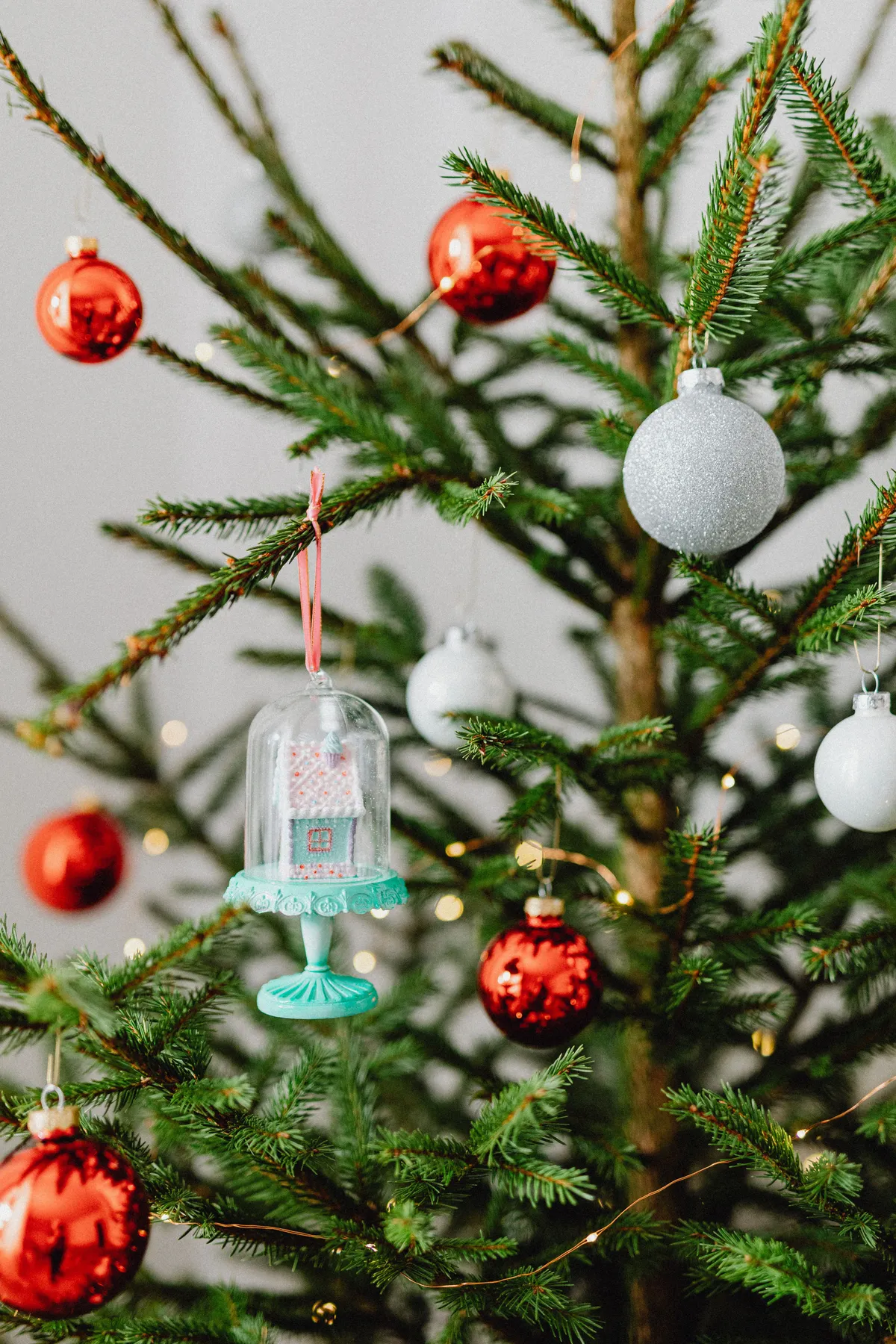 A beautifully decorated Christmas tree featuring vibrant red and silver ornaments indoors.