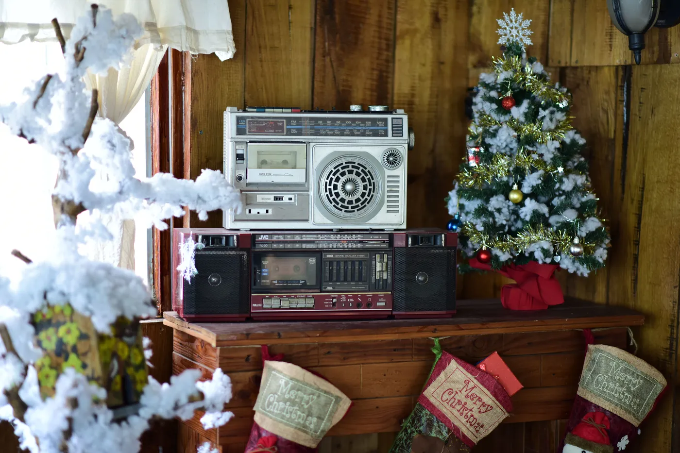 A charming Christmas scene featuring a vintage radio, decorated tree, and festive stockings.