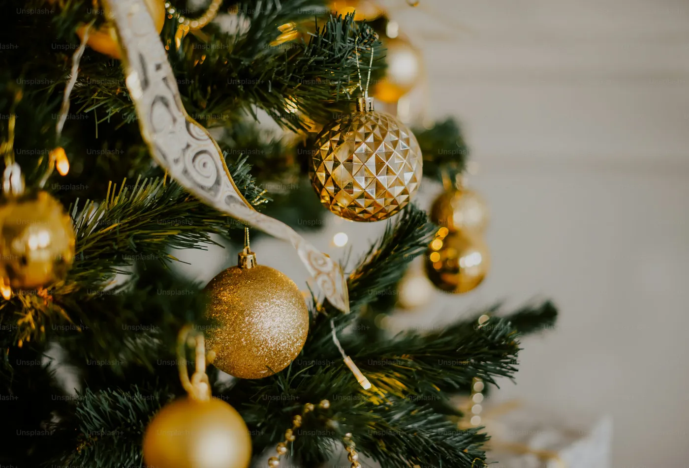 A close up of a christmas tree with ornaments - Photo on Unsplash+