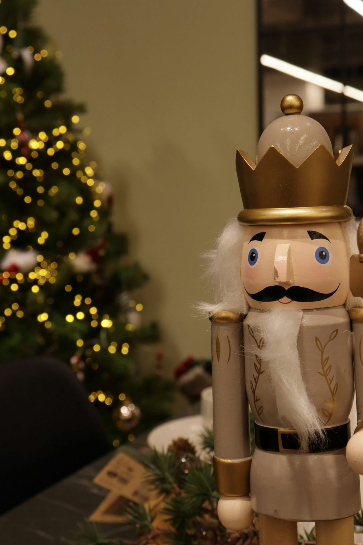 A nutcracker stands beside a decorated christmas tree - Free Photo on  Unsplash