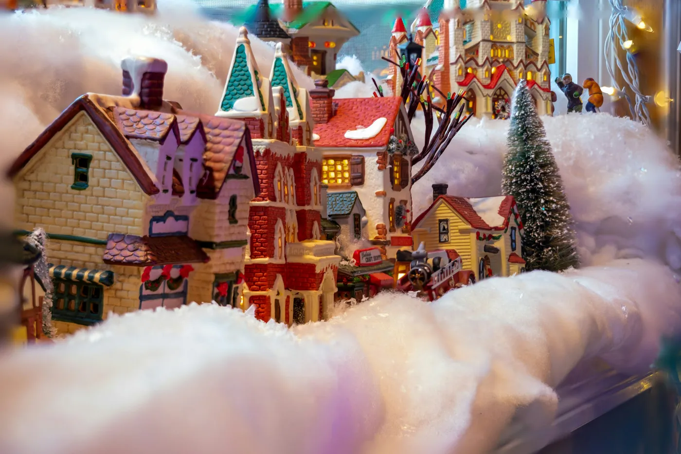 A snow covered town with a christmas tree and a snowman - Free Photo on  Unsplash