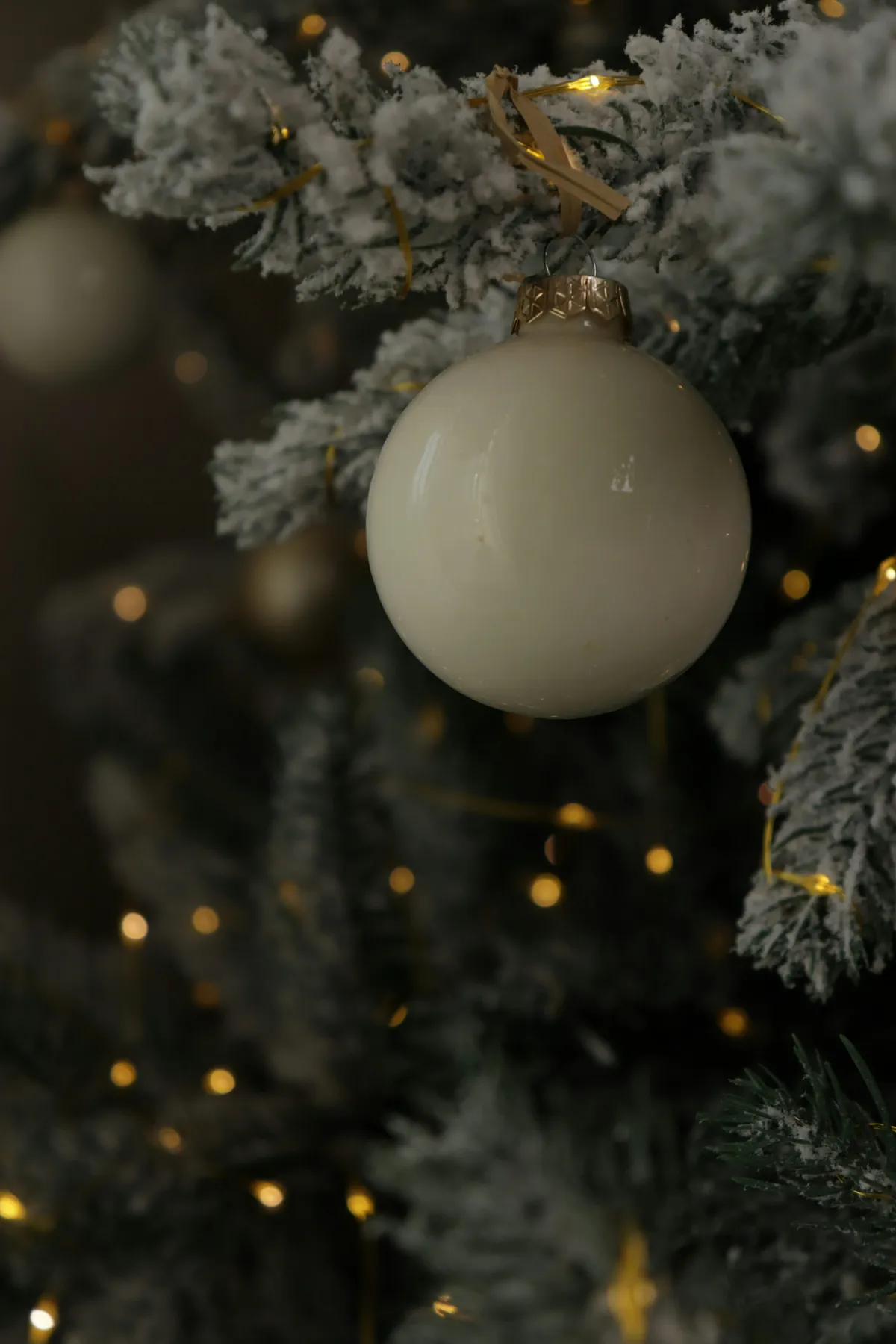 A white ornament hangs on a snowy christmas tree - Free Photo on Unsplash