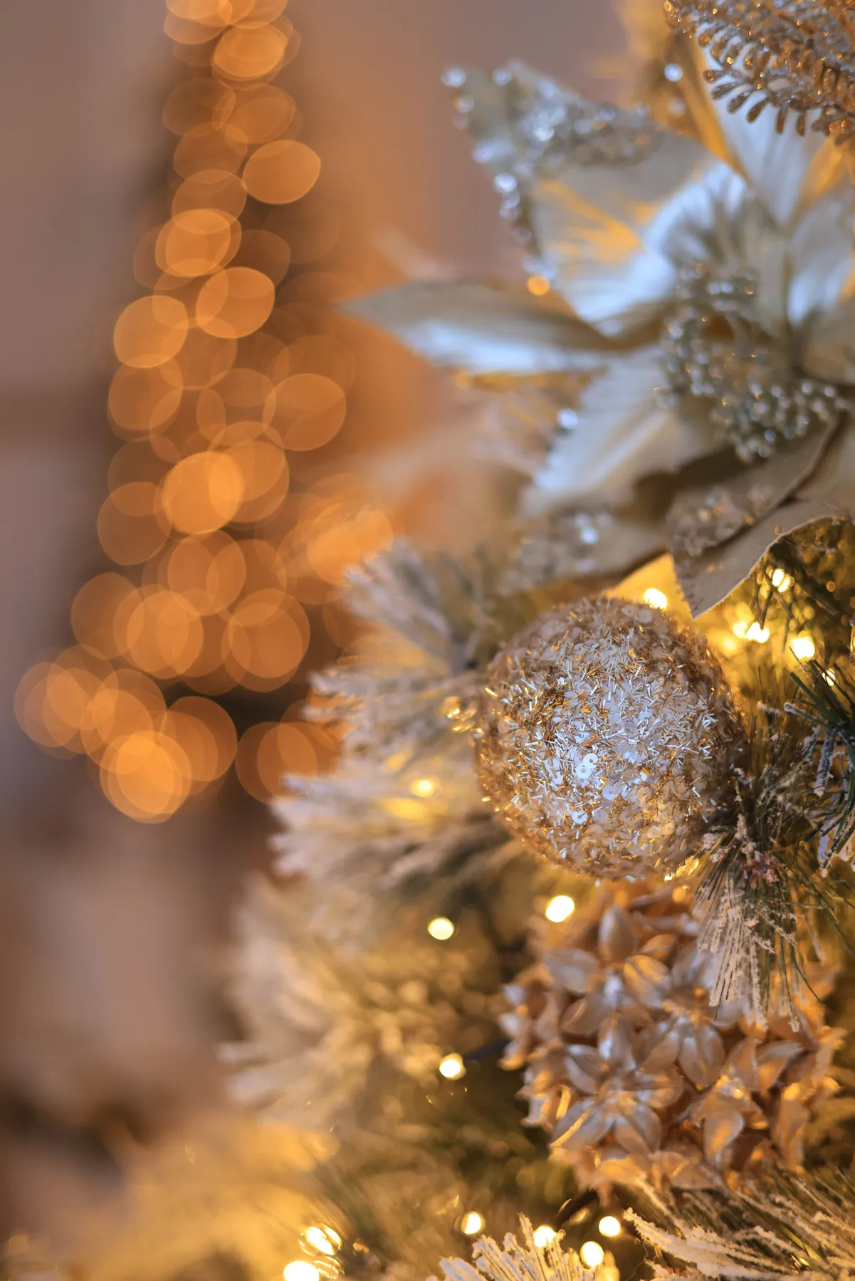 Close-up of a beautifully decorated Christmas tree with golden lights and ornaments, capturing the holiday spirit.