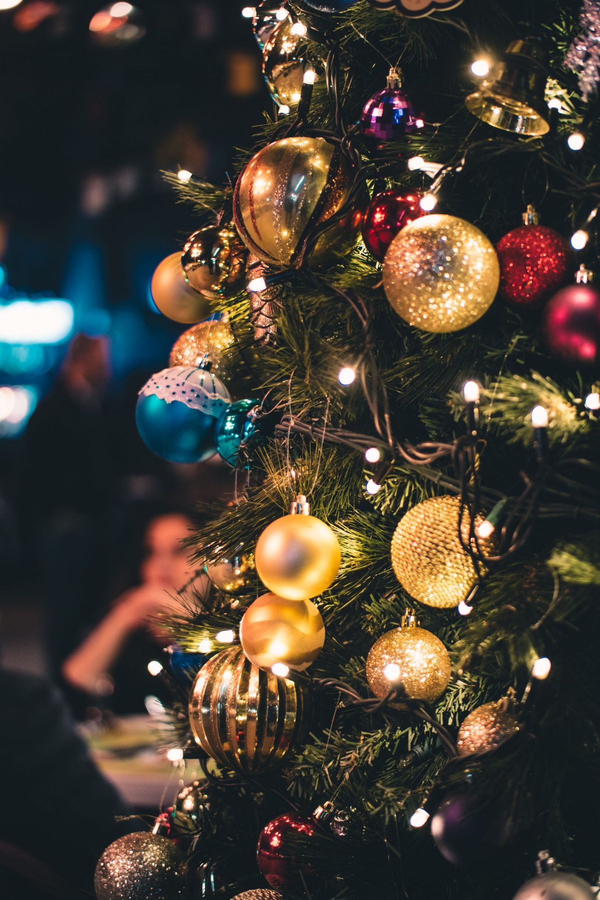 Close-up of a Christmas tree adorned with vibrant ornaments and lights.