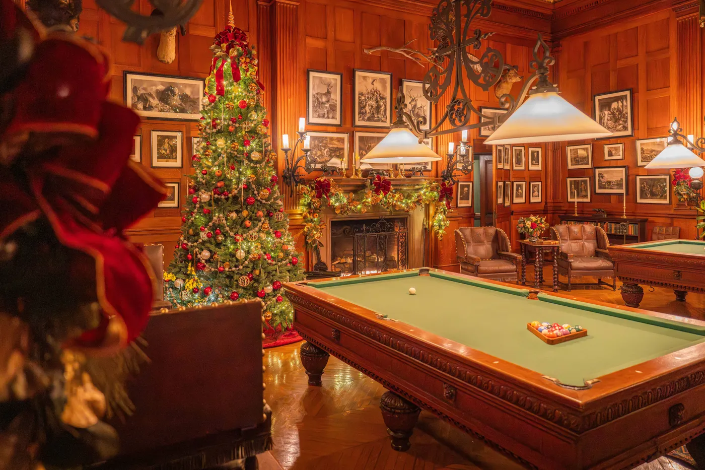 Cozy billiard room with Christmas tree and festive decor creating a warm holiday ambiance.