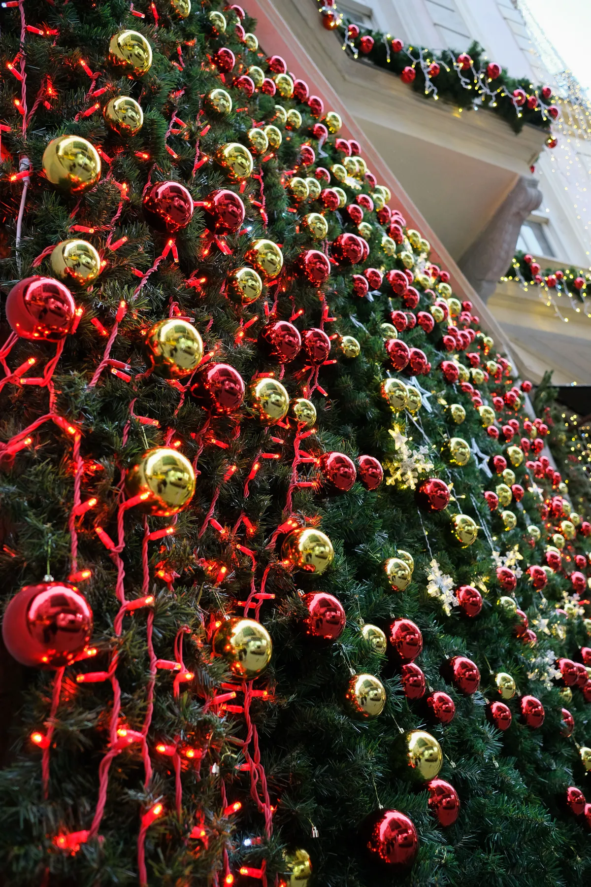 Festive Christmas tree with red and gold ornaments lit by glowing lights.