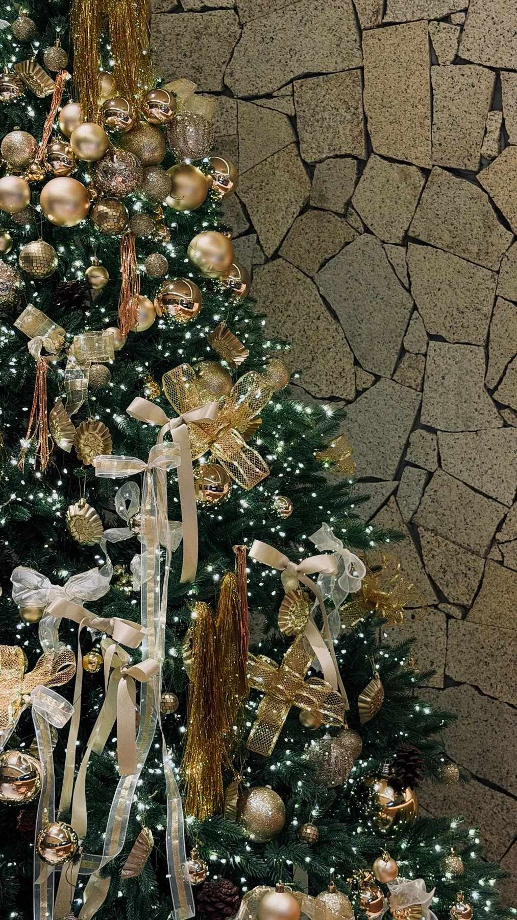 Gold-adorned Christmas tree with lights and ribbons in Ho Chi Minh City.