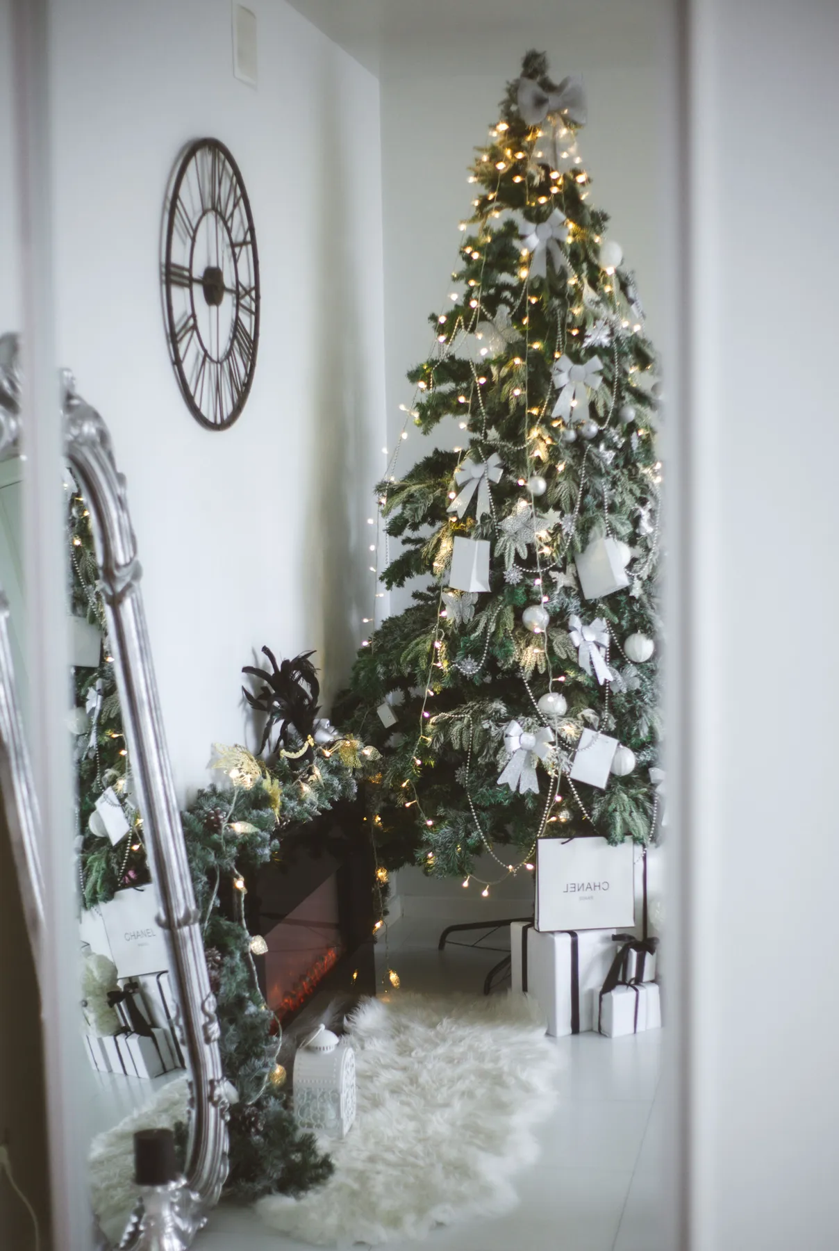 Stylish indoor holiday setting with a decorated Christmas tree, presents, and festive garland.
